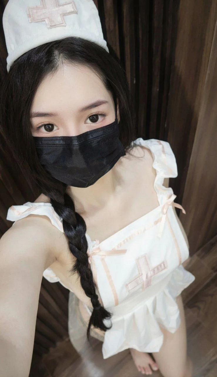 하얀 간호사 콘셉트 의상을 입고 셀카를 찍는 미나